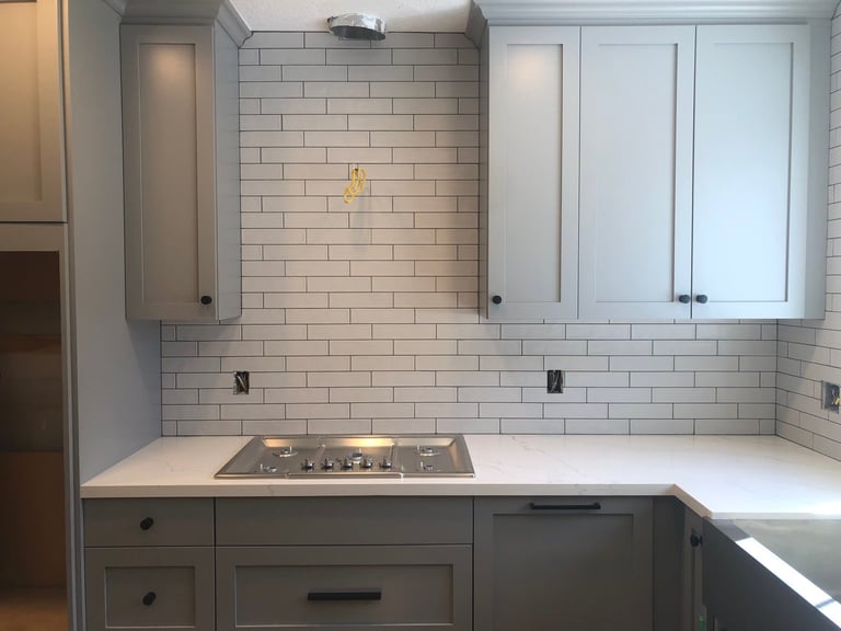 Modern kitchen with white subway tile backsplash and white cabinetry